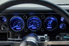 the interior of a car with blue lights and gauges