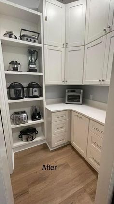 a kitchen with white cabinets and wood floors