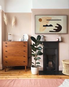 a living room with pink walls and a wooden dresser next to a painting on the wall