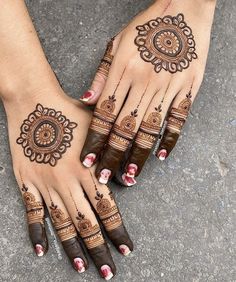 two hands with hendi designs on them