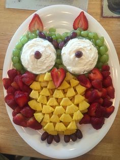 a white plate topped with fruit and an owl face