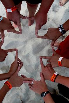 a group of people standing in a circle with their hands together