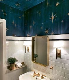 a bathroom with stars painted on the ceiling and blue walls, along with gold fixtures