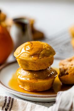 three pumpkin muffins stacked on top of each other with caramel sauce drizzled over them