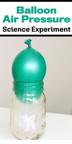 a green ballon air pressure science experiment in a glass jar on a white table