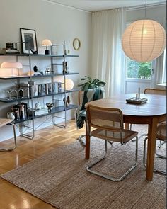 a dining room table with chairs and bookshelves