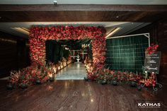 an entrance decorated with red flowers and greenery for a wedding or special event venue