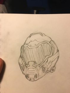 a drawing of a helmet on top of a piece of paper in someone's hand