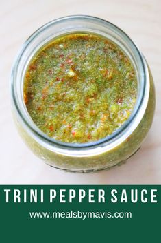 a jar filled with green sauce sitting on top of a table