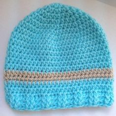 a crocheted blue and tan hat sitting on top of a table