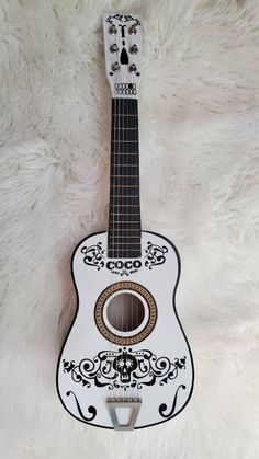 a white and black ukulele with an ornate design