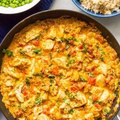 a pan filled with chicken and rice next to peas