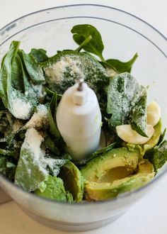 an avocado and spinach in a food processor with powdered sugar on top