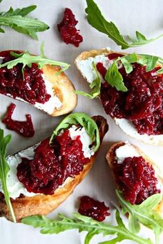 cranberry sauce is spread on top of toasted bread and garnished with green leaves