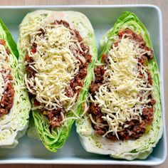 three lettuce boats filled with meat and cheese on top of a white plate