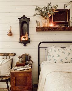 a bedroom with a bed, nightstand and mirror on the wall next to an old dresser