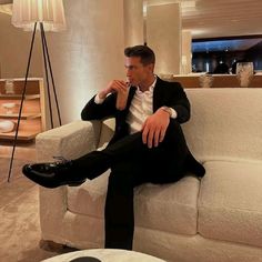 a man in a suit sitting on a couch