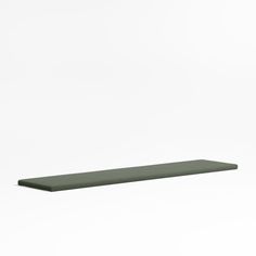 a green shelf sitting on top of a white wall