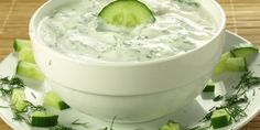 a white bowl filled with cucumber and sour cream