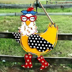 a chicken with glasses and polka dots on it's head is standing in front of a fence