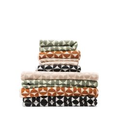 four towels stacked on top of each other in different colors and patterns, all folded up