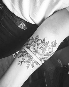 a woman's arm with flowers on it and a cross in the middle is shown