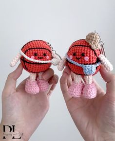 two hands holding small crocheted items in the shape of basketballs, one with a hoop on its head