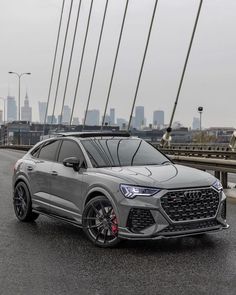 the new audi q3 suv is shown in front of a cityscape background