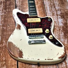 an old, worn out guitar sitting on top of a wooden table with no strings