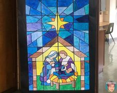 a stained glass window with a nativity scene in the center and stars above it