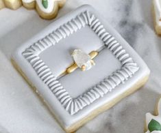 some decorated cookies are on a table with white and gold trimmings in the shape of flowers