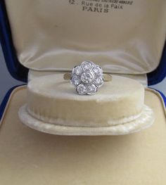 an antique diamond cluster ring in a velvet case, with the box open to show it's contents