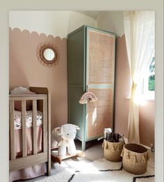 a baby's room with pink walls, white carpet and wooden cribs