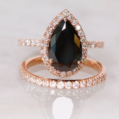 a close up of a ring with a black stone in the middle and white diamonds around it