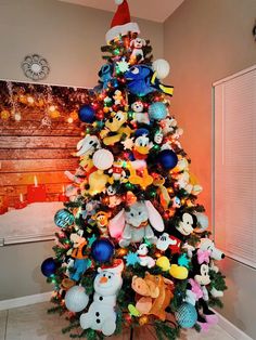 a christmas tree with many different stuffed animals on it and decorations around the base,