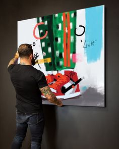 a man is painting on the wall with his hands