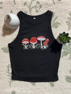 This adorable black crop top is the perfect basic top for any casual outfit but can also be used to elevate any look. It is a solid item to keep in your closet. It is flattering and comfortable. The sleeveless racerback crop is made of cotton, polyester and spandex. It is very soft, stretchy, breathable, and snug to your skin. Mushroom design is machine embroidered and made to order. Crop top fits true to size so whatever is your regular size will fit.  It is available in brown and white and the same sizing applies for those colors as well. Don't hesitate to reach out to me if there are any problems with your order. Cropped Y2k Tops For Fall, Fall Cropped Y2k Tops, Spring Black Crop Top, Cropped Cotton Tank Top For Fall, Fall Cropped Cotton Tank Top, Trendy Tank Crop Top For Fall, Casual Crop Top Tank For Fall, Casual Fall Crop Top Tank, Black Cropped Tops For Spring