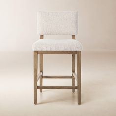 a white upholstered chair on a beige background