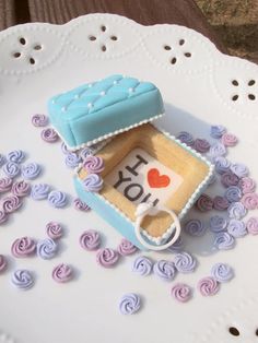 a cake shaped like a box with a ring on it sitting on top of a doily