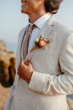 a man in a white suit and flower boutonniere