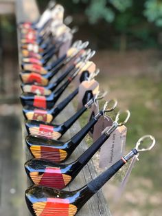 several pairs of scissors are lined up on a wooden table with tags attached to them