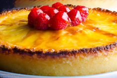 a close up of a cake with raspberries on top