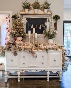 a white dresser topped with lots of christmas decorations