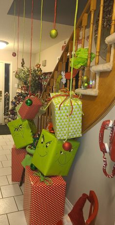 christmas presents are hanging from the banisters on the stairs in this hallway decorated with green and red wrapping