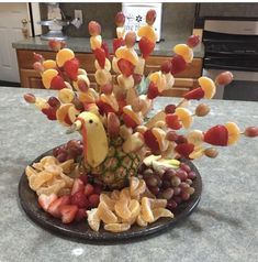 a platter filled with fruit and a bird figurine