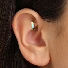 a woman's ear with an opal in the middle