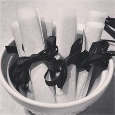 black and white photograph of napkins in a bowl with ribbons on them, ready to be eaten