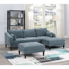 a blue sectional sofa sitting on top of a rug in front of a book shelf