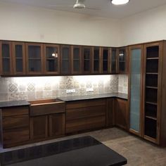 an empty kitchen with wooden cabinets and tile backsplash