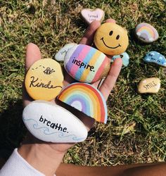 someone is holding some rocks in their hand with rainbow painted on them and the words inspire written on them